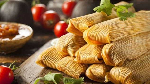 Tamales (Mexico): Tamales là món bánh được làm từ bột ngô nhồi thịt, phô mai, các gia vị đi kèm thơm ngon khác, bọc trong lá chuối hoặc vỏ ngô và thường xuất hiện vào dịp đặc biệt ở Mexico. Đầu năm mới, nhiều gia đình hay những nhóm phụ nữ sẽ tập hợp lại, phân chia các công đoạn để cùng nhau tạo ra hàng trăm gói bánh nhỏ xinh. Khi thưởng thức, bạn sẽ ăn kèm cùng món súp không kém phần nổi tiếng của đất nước này. Đến đây vào năm mới, bạn sẽ dễ dàng bắt gặp những nhà hàng bán Tamales cả ngày lẫn đêm.