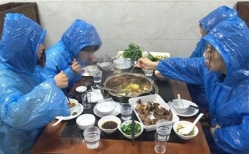 Lý do khiến 4 cô gái trẻ vừa mặc áo mưa vừa xì xụp ăn lẩu