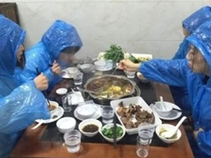 Lý do khiến 4 cô gái trẻ vừa mặc áo mưa vừa xì xụp ăn lẩu