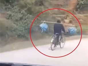 CLIP: Người đi xe đạp gánh hàng hóa khi đang chạy