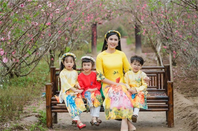 Hoa hậu Việt Nam 2010 cùng các em nhỏ diện áo dài do cô thiết kế trong bộ ảnh Tết. 
