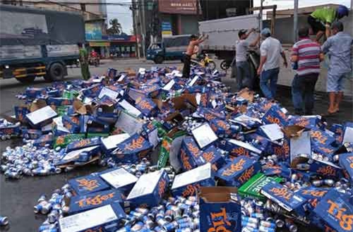 Người dân Bình Thuận giúp tài xế gom hàng trăm thùng bia đổ ra đường