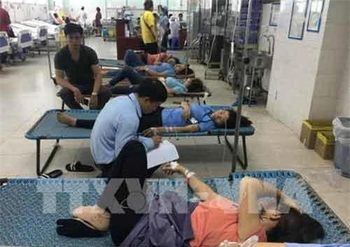 Công nhân nghi ngộ độc thực phẩm đang được cấp cứu tại Bệnh viện quận Tân Phú. (Ảnh: TTXVN)