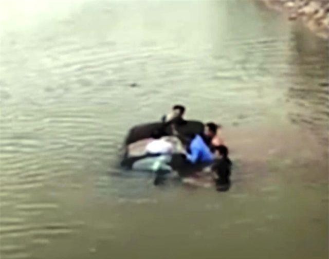 CLIP: Người dân đập cửa kính cứu tài xế chiếc ôtô đang chìm dưới sông ở Nam Định