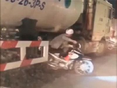 CLIP: Hàng loạt xe máy chui qua gầm xe bồn để sang đường