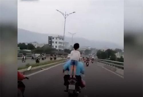 CLIP: Bé gái không đội mũ bảo hiểm, đứng trên yên xe đang chạy khiến người xem ‘thót tim’