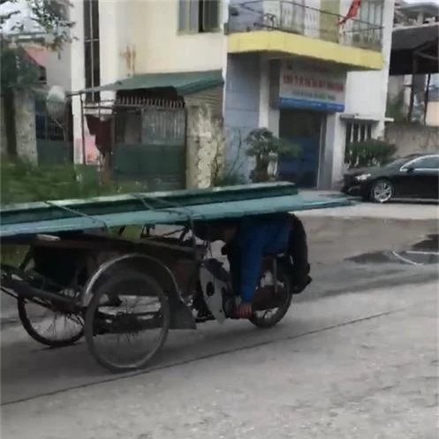 Clip: Người đàn ông nằm úp bụng lên yên, dùng lưng lái xe chở tôn chạy vi vu ngoài đường - Ảnh 2.