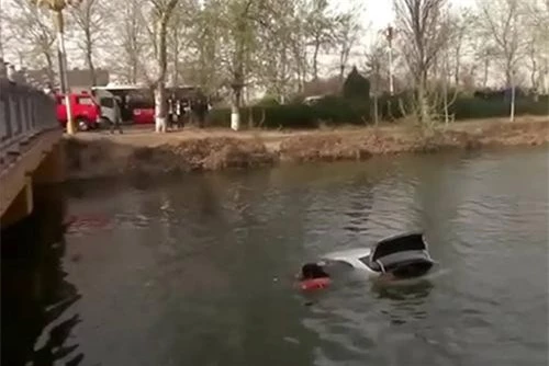 Người phụ nữ hoảng hốt vì mắc kẹt ở ghế tài xế trong khi chiếc xe đang dìm dần xuống hồ.