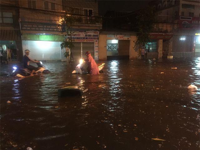 Người dân Biên Hòa bì bõm lội nước sau cơn mưa lớn đầu mùa