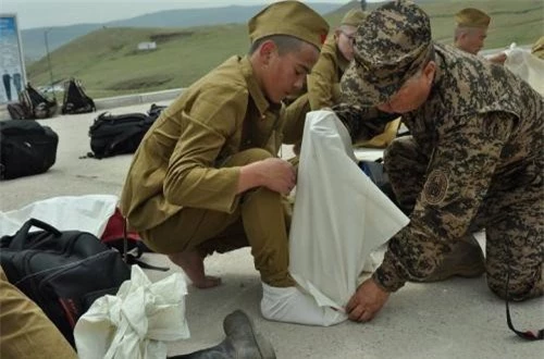 Một sĩ quan huấn luyện đang giúp tân binh bó vải vào chân trước khi đi bốt cao cổ. Đáng ngạc nhiên là mẫu bốt khá giống kiểu mà Hồng quân Liên Xô dùng trước đây. 