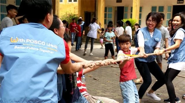 Các em học sinh và nhân viên công Công ty Posco E&C cùng nhau chơi kéo co