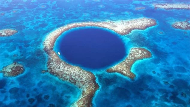 5. Great Blue Hole (Hố xanh lớn), Belize Với chiều rộng 300 mét và sâu khoảng 125 mét, Great Blue Hole là hố chìm lớn nhất thế giới ngoài khơi bờ biển Belize, nằm giữa ngọn hải đăng và một đảo san hô nhỏ, cách đất liền và thành phố Belize 70km. Là một phần của hệ thống Rạn san hô hàng rào Belize, hố này được hình thành khi mực nước biển dâng lên hàng ngàn năm trước, làm ngập các hang động sâu của nó. Nó trở nên nổi tiếng nhờ nhà thám hiểm biển Jacques Cousteau, khi ông công bố một bản đồ 3D được dựng từ các chuyến thám hiểm bằng tàu ngầm của mình. Bản đồ cho thấy các thành tạo khoáng sản chưa từng thấy gần đáy hố.