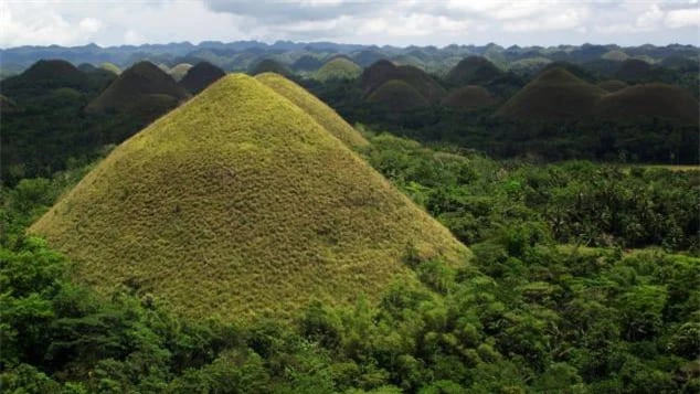 8. Đồi sôcôla, Philippines Đồi sôcôla lăn Bohol ở Philippines có thể dễ dàng bị nhầm lẫn với bức vẽ phong cảnh của trẻ em. Nhưng 1.268 ngọn đồi này là một hiện tượng tự nhiên: các đỉnh đá vôi hình nón được hình thành do các hoạt động của nước và xói mòn trong hàng ngàn năm. Tên của chúng bắt nguồn từ lớp phủ cỏ của chúng khi chuyển sang màu nâu trong mùa khô vào tháng 12 đến tháng 3 và cũng là thời điểm đẹp nhất để ghé thăm. Truyền thuyết kể rằng những ngọn đồi là những giọt nước mắt khô của một người khổng lồ đau khổ.