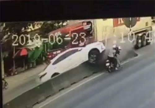 Ôtô con bị hất tung lên dải phân cách do tạt đầu xe container