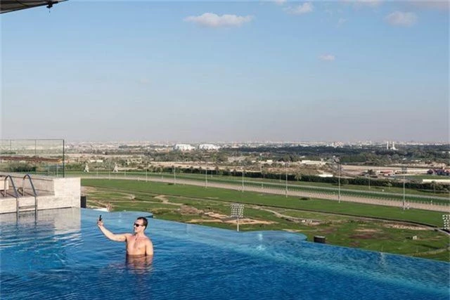 Bể bơi trên tầng thượng hay hồ bơi vô cực nằm tại khách sạn Meydan. Phía sau đó là trường đua ngựa Meydan nổi tiếng, nơi có thể chứa tới 60,000 người xem. Một du khách nam đang thư thái chụp hình trên bể bơi, nơi tầm nhìn hướng về trường đua ngựa.