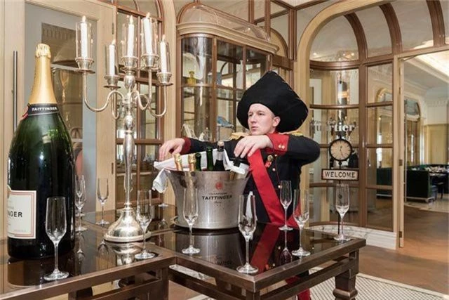 Một nhân viên đang phục vụ rượu champagne chào đón khách VIP tới khách sạn St Regis sang trọng. Đây là một trong những khách sạn xa hoa bậc nhất, chỉ giới thượng lưu ở Dubai mới lui tới.