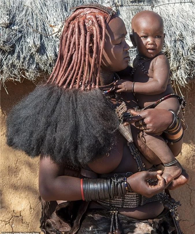 Hình ảnh độc đáo về bộ tộc sống cách biệt với thế giới: Không tắm bằng nước, phụ nữ ở trần, dùng đất sét để làm tóc và trang điểm - Ảnh 2.