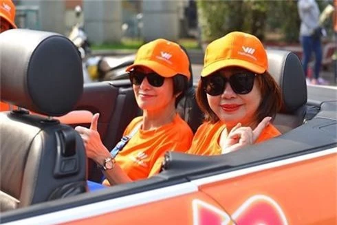 Bà Elizabete Fong (người ngồi bên trái), người được mệnh danh là “người đàn bà thép” của Vietnamobileở cái tuổi gần 70 vẫn tràn đầy năng lượng trẻ trung ngồi trên xe ô tô mui trần đi trên đường phố các tỉnh miền Nam để quảng bá cho gói cước 4G của nhà mạng này.