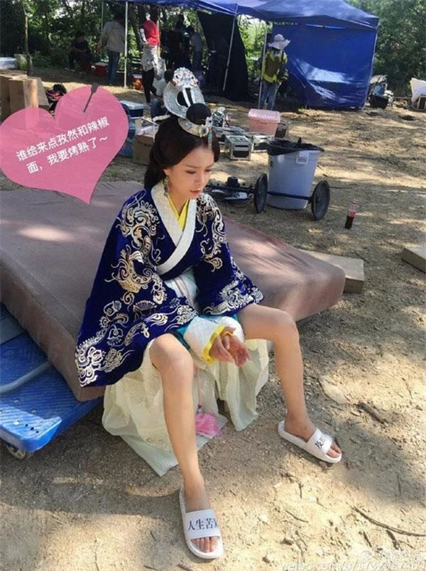 Nữ MC kiêm diễn viên Thẩm Mộng Thần không ngại vén váy trên phim trường “Trùng nhĩ truyện” vì quá nóng. Ảnh: Webo