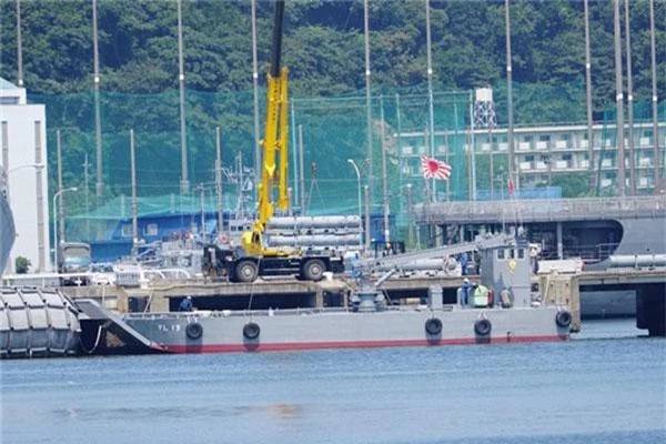 Mạng xã hội quân sự Nhật Bản ngày 31/7 đăng tải bức ảnh lạ được chụp tại một quân cảng. Trong ảnh có thể thấy các xe cẩu đang được hai ống phóng tên lửa lên tàu đổ bộ cơ giới cỡ nhỏ lớp YL-09. Nguồn ảnh: Dambiev