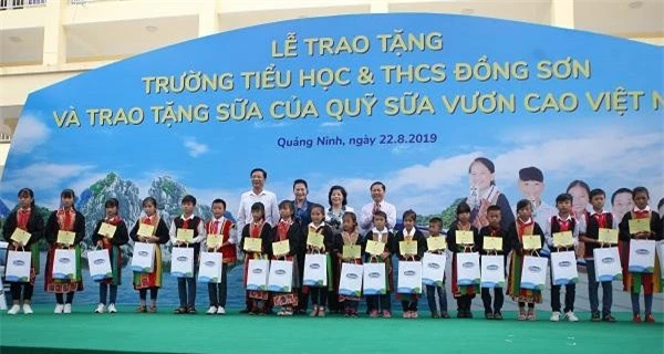Chủ tịch Quốc hội Nguyễn Thị Kim Ngân trao tặng bảng tượng trưng tặng trường Tiểu học & THCS Đồng Sơn, huyện Hoành Bồ, tỉnh Quảng Ninh cho đại diện lãnh đạo trường và các em học sinh.