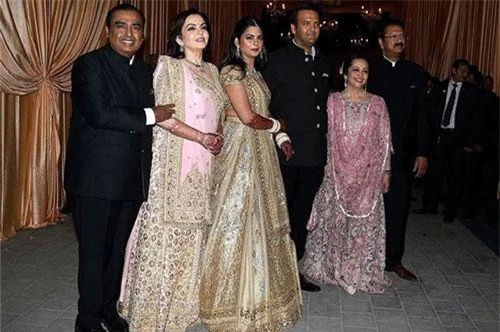 Vợ chồng tỷ phú Mukesh Ambani (trái) và vợ chồng doanh nhân Ajay Piramal (phải) trong tiệc cưới của hai đứa con họ là Isha Ambani và Anand Piramal (giữa) vào tháng 12/2018. Ảnh: Bloombeg. 