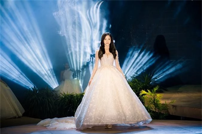 NTK của Bella Bridal Vietnam cho biết, thiết kế này được đính 17.568 viên pha lê, do 5 nghệ nhân thực hiện thủ công trong 172 liên tục. Thiết kế vai và tay trong suốt kết hợp cùng những họa tiết thêu chìm tạo nên tinh thần lãng mạn và sự lộng lẫy cho bộ lễ phục. 