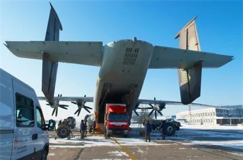 An-22 có tải trọng lên tới 80 tấn cho phép chứa kiện hàng cỡ lớn. Trong ảnh là nguyên một chiếc xe đầu kéo với container đang từ từ được đưa ra khỏi khoang hàng An-22. Ảnh: English Russia