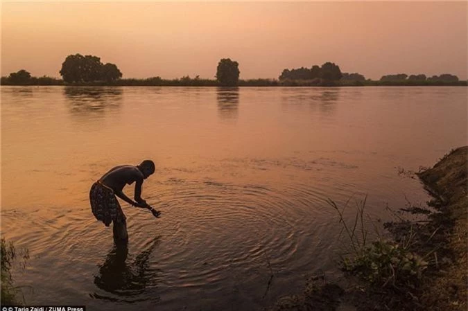 Một người phụ nữ của bộ tộc tắm ở sông Nile trong ánh hoàng hôn. Sau khi nội chiến kết thúc, hàng nghìn nam giới trở về Nam Sudan tìm vợ, khiến phụ nữ trở nên có giá.