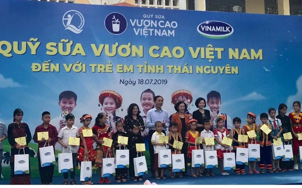 Bà Trương Thị Mai - Ủy viên Bộ Chính trị, Bí thư Trung ương Đảng, Trưởng ban Dân vận Trung ương trao những hộp sữa của Quỹ sữa vươn cao Việt Nam đến các em học sinh tham dự chương trình