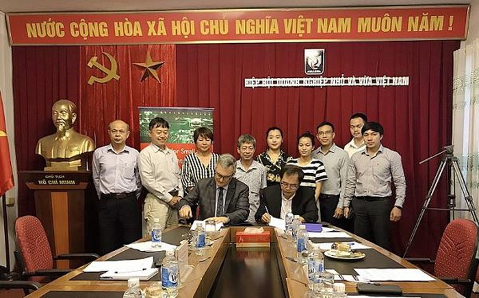 Ông Tô Hoài Nam và ông Ron Askin kí kết chương trình hợp tác hỗ trợ DNNVV Việt Nam tham gia chuỗi cung ứng toàn cầu.