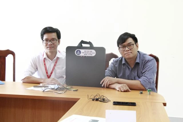 Anh Tôn Thất Trường Nam (bên phải) và thầy Trần Quốc Lâm bên cạnh chiếc máy phát hiện gian lận trong thi cử.