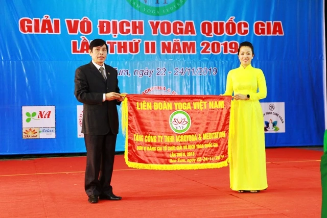 Bà Lê Thị Trúc Quỳnh, Giám đốc Công ty TNHH Acroyoga & Meditation - đơn vị đăng cai nhận cờ lưu niệm của Ban tổ chức.