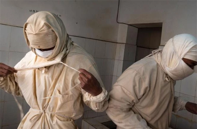 Nhân viên một trung tâm phòng chống dịch bệnh Trung Quốc mặc đồ bảo hộ trước khi bước vào phòng thí nghiệm