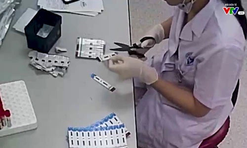 Nhân viên xét nghiệm của Bệnh viện đa khoa Xanh Pôn cắt đôi que thử.