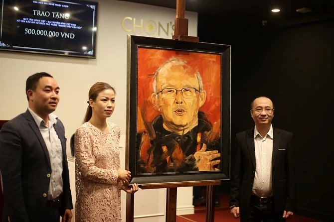 Ông Nguyễn Phan Huy Khôi, đại diện Tập đoàn Bảo Ninh (bên phải) đã đấu giá thành công bức tranh Người thầy của tôi với giá 12.000 USD và ủng hộ thêm hơn 221 triệu đồng cho Quỹ Tấm lòng Việt.