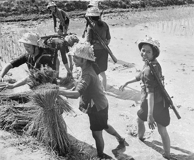 Một nhóm nữ dân quân ở Thanh Hóa đi làm ruộng nhưng vẫn đeo súng trên người để sẵn sàng chiến đấu mọi lúc mọi nơi. Đây là một trong những bức ảnh quý giá về Chiến tranh Việt Nam được chụp vào ngày 18/10/1967.