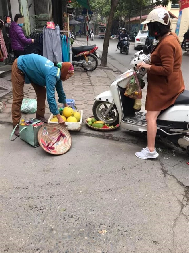 Phẫn nộ hình ảnh người phụ nữ mang bầu lái xe máy cán thẳng qua nia trái cây của cô bán hàng rong ven đường vì ngồi chắn trước cửa hàng - Ảnh 2.