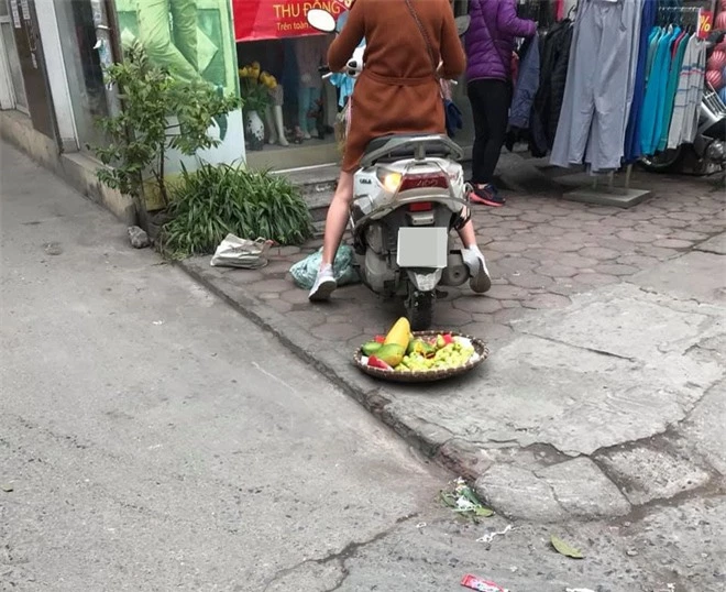 Phẫn nộ hình ảnh người phụ nữ mang bầu lái xe máy cán thẳng qua nia trái cây của cô bán hàng rong ven đường vì ngồi chắn trước cửa hàng - Ảnh 3.