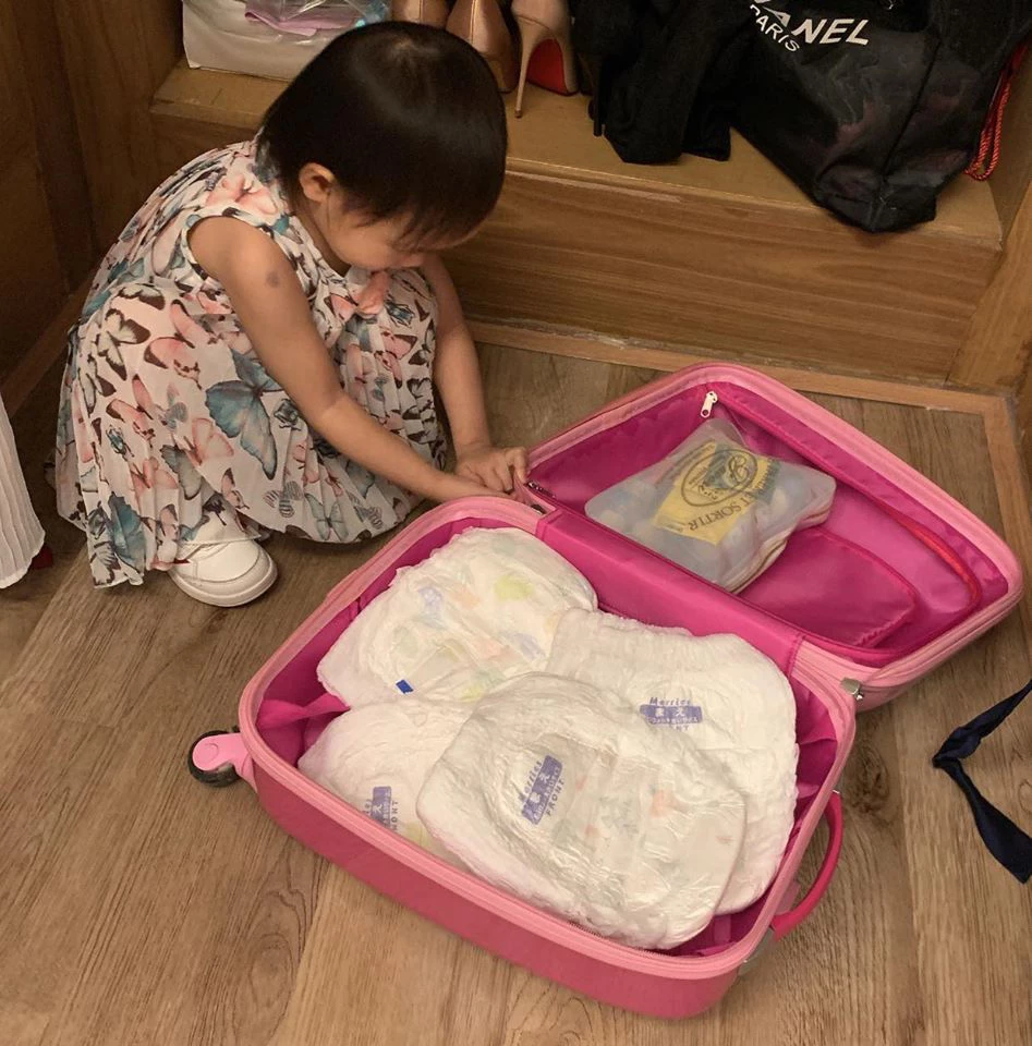 Cô bé tự sắp xếp hành lý, gấp quần áo của mình.
