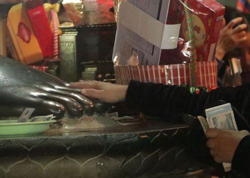 Chen chúc xếp hàng xoa tiền lên chân tượng Phật cầu may ở Hà Nội