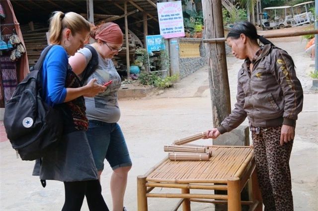  Du khách nước ngoài ghé mua những đôi đũa vót bằng phương pháp thủ công của vợ chồng bà Thòa. 