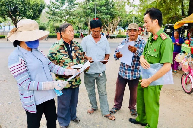 Công an tỉnh Bình Dương phát tờ rơi có lệnh truy nã đối tượng Lê Quốc Tuấn đến người dân.