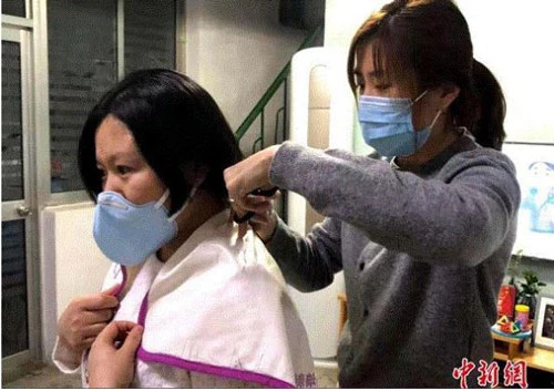Trước khi lên đường chiến đấu với bệnh dịch, một y tá bệnh viện thuộc Đại học Sơn Đông (Tế Nam, Trung Quốc) cắt đi mái tóc dài của mình để thuận tiện làm việc. (Ảnh: Chinanews)
