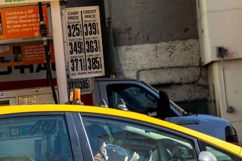 Một tài xế taxi đeo găng tay cao su vào đổ xăng trong khi giá xăng đã giảm do Covid-19 tại New York, Mỹ, ngày 14/3. Ảnh: Getty.