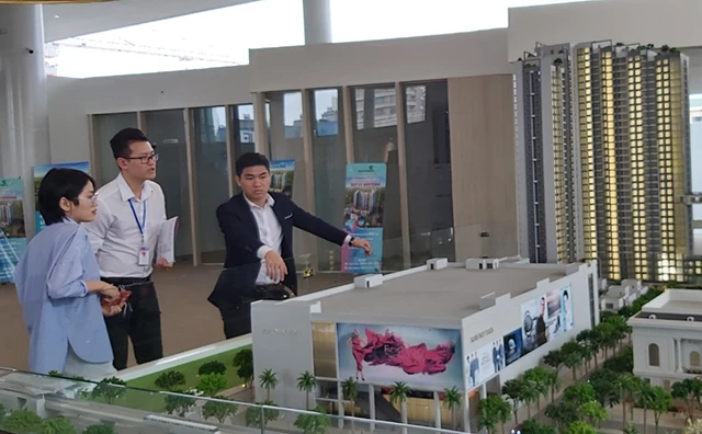 Nhân viên sàn giao dịch bất động sản giới thiệu mô hình một dự án chung cư cao cấp trên đường Xuân Thuỷ