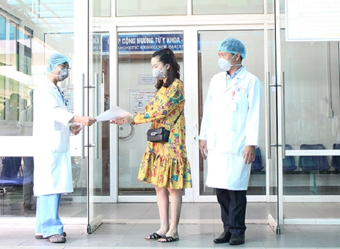 Lãnh đạo Bệnh viện Đà Nẵng trao giấy chứng hoàn thành cách ly, điều trị và giấy xuất viện cho chị N.T.T.N (danang.gov.vn)