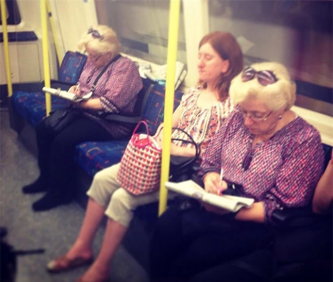 Hai người phụ nữ trên chiếc xe buýt giống nhau từ phong cách ăn mặc đến kiểu tóc.