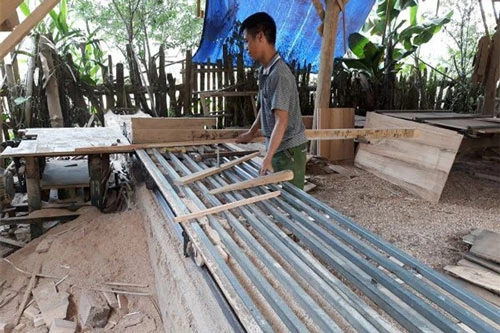 Anh Trương Văn Thủy bên  sáng chế máy xẻ gỗ cải tiến cho năng suất cao
