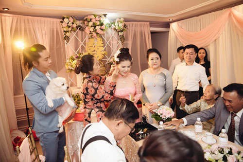 Đang tổ chức lễ cưới, nhưng chú rể vẫn phải đứng bế "kẻ thứ ba" này để người khác đeo nữ trang cho vợ